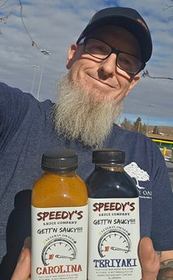 Matt Martin holding bottles of Speedy's sauces